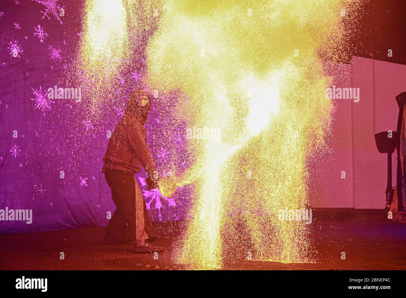 Amazing view of fire performer standing on a stage Stock Photo