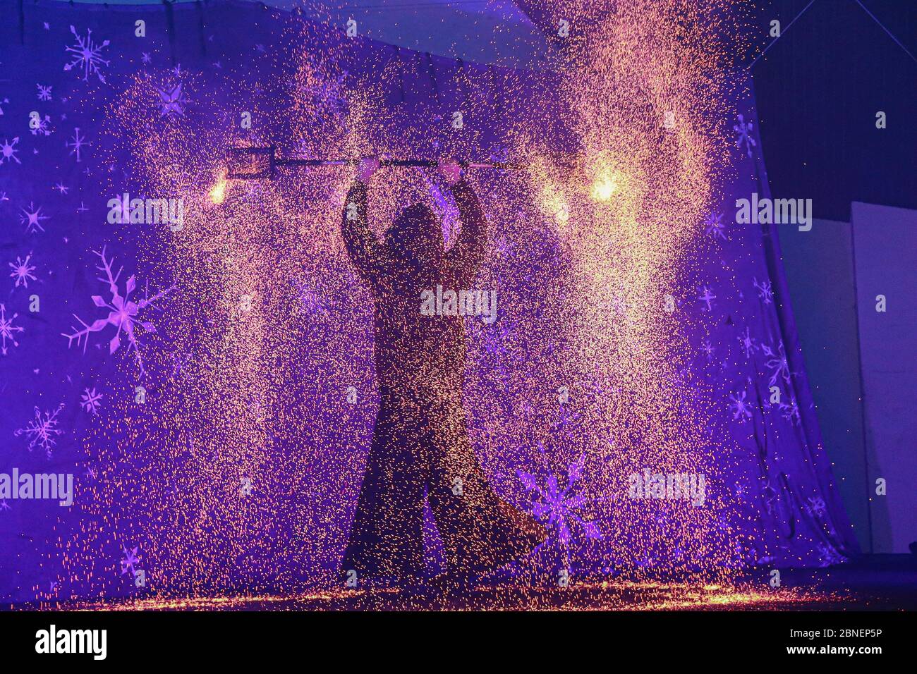 Amazing view of fire performer standing on a stage Stock Photo