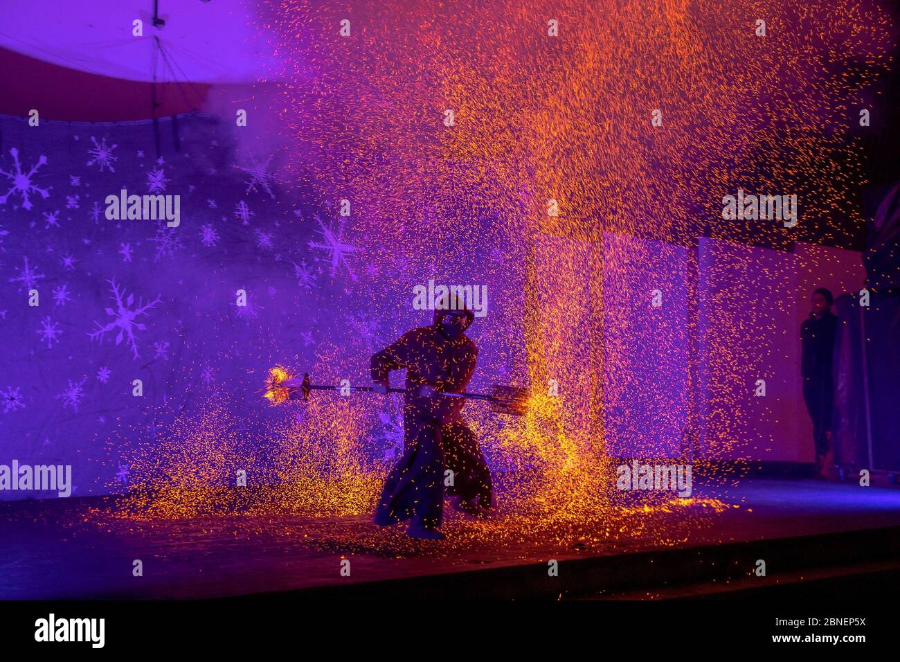 Amazing view of fire performer standing on a stage Stock Photo