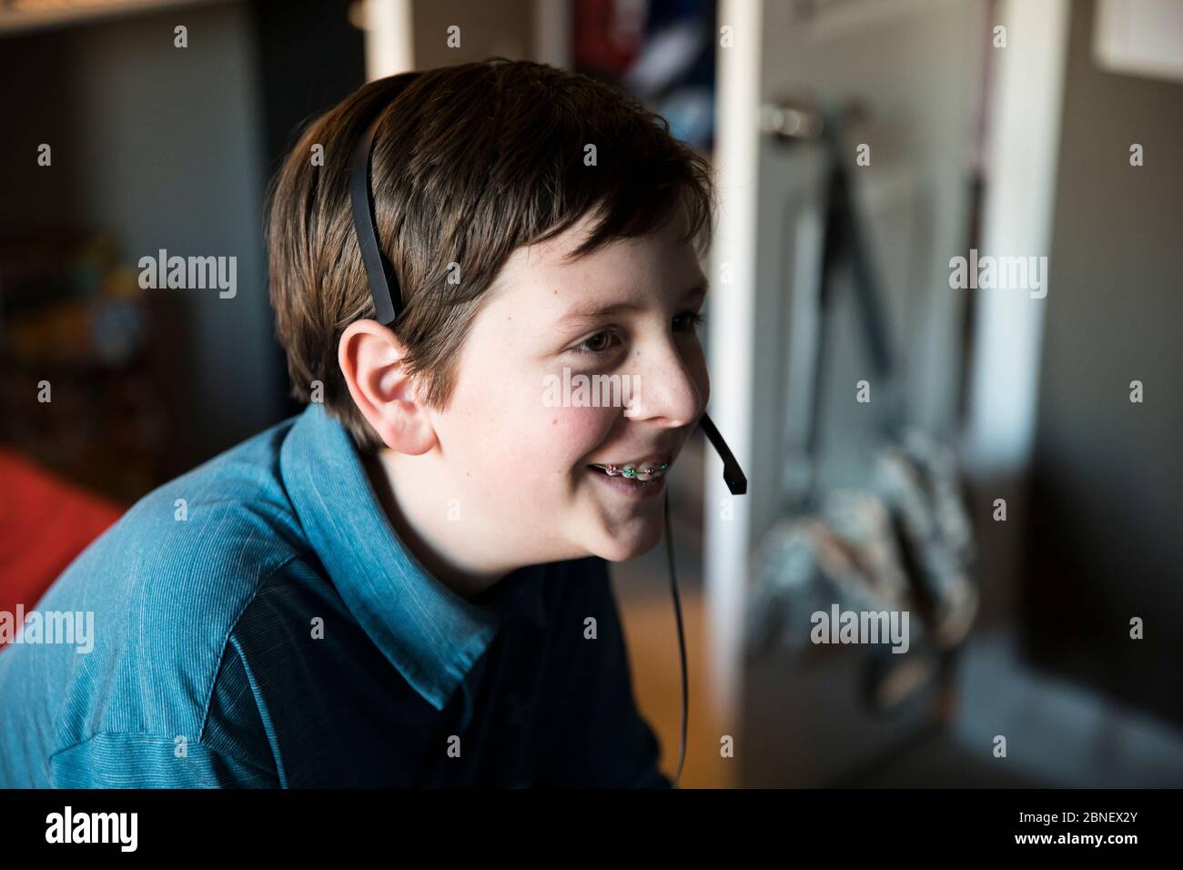 Side View of Smiling Teen With Braces Wearing Gaming Headset Stock