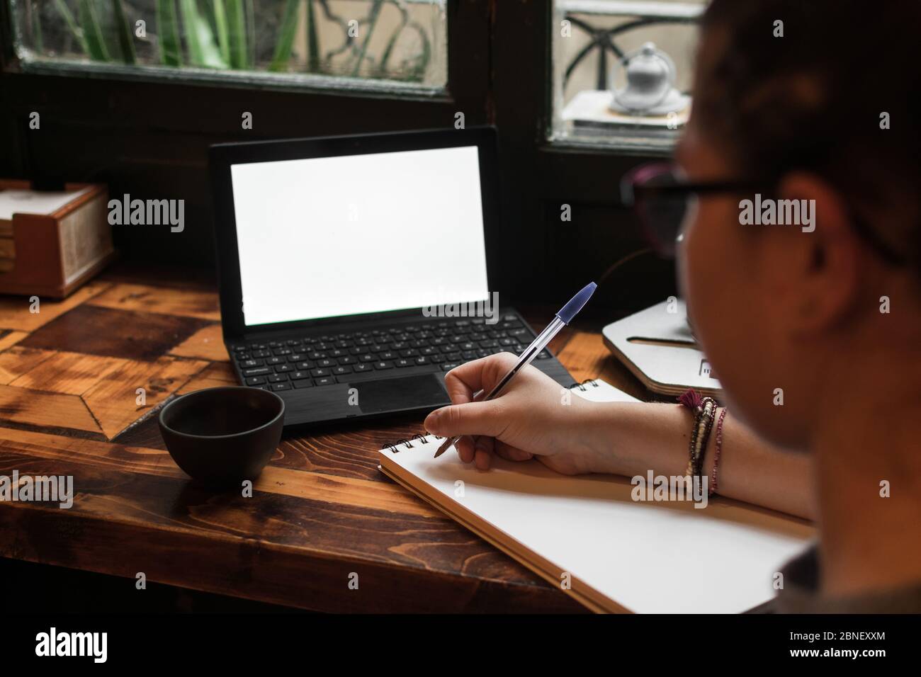 A young student works on a table near a pub window. Close up view Stock Photo