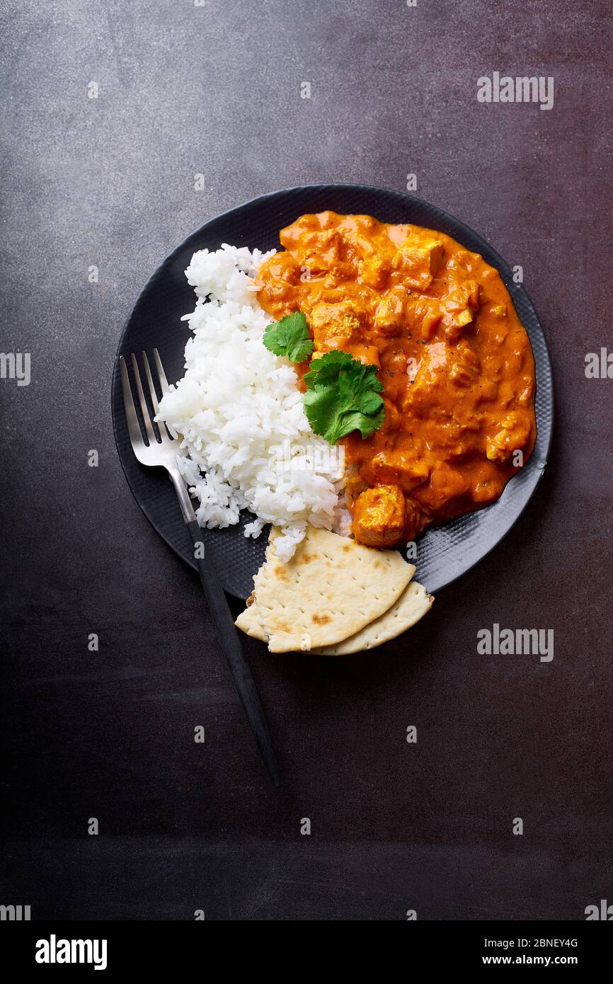 Paneer tikka masala with basmati rice. Indian cuisine, vegetarian dish made of soft cheese cubes cooked in spicy tomato sauce with cream. Top view, da Stock Photo