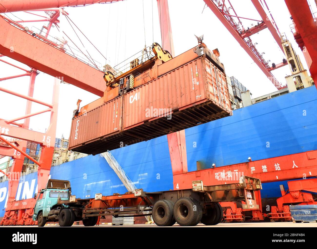 Trucks are busy at loading containers on vessels which export goods ...