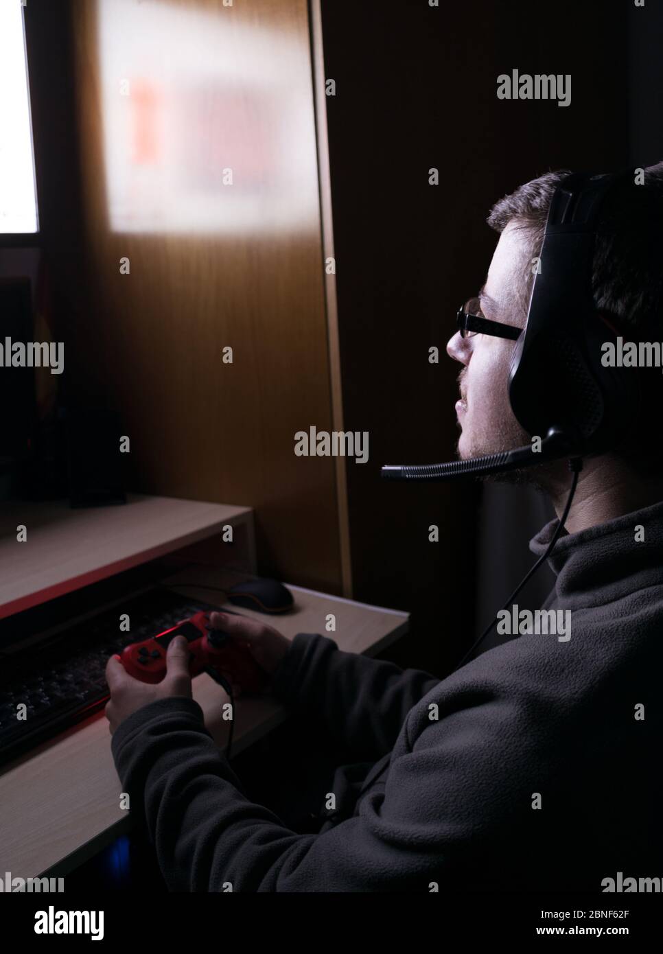 Young man playing video games in the dark in his room Stock Photo Alamy