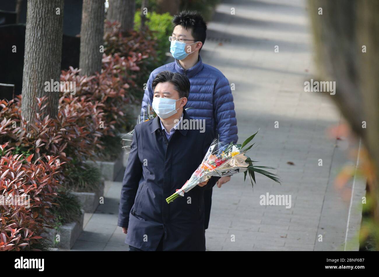 People hold flowers walking at Yuhuatai Gongdeyuan Cemetery in Nanjing city, east China's Jiangsu province, 4 April 2020. Stock Photo