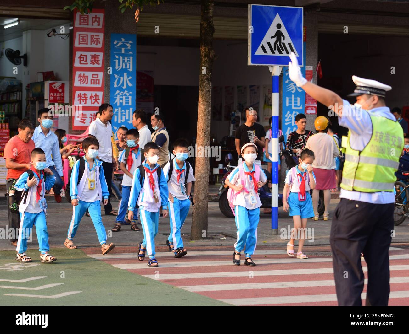 Students queue with a suitable distance under the guidance of a ...