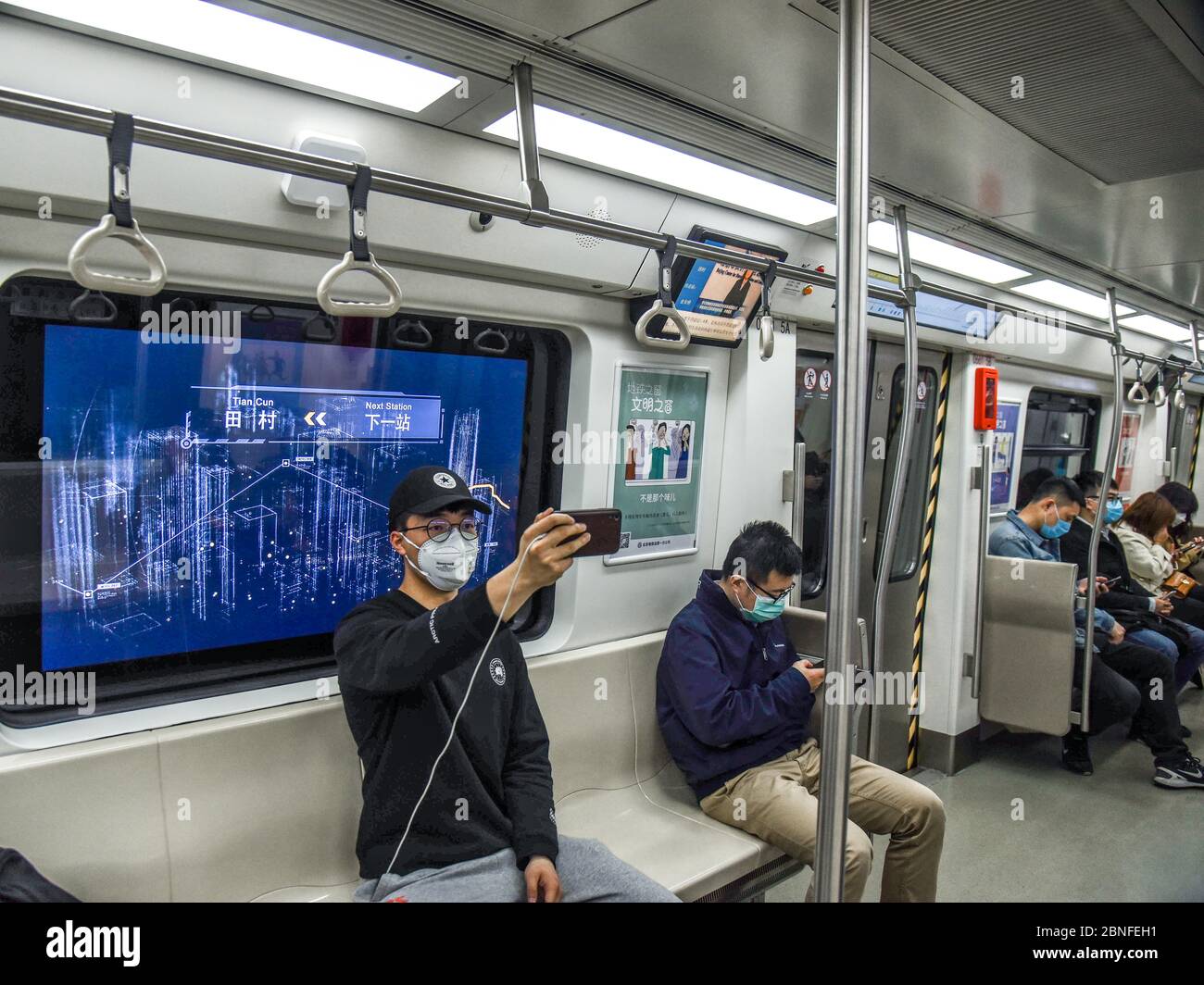 Students play online games inside a subway train in Beijing