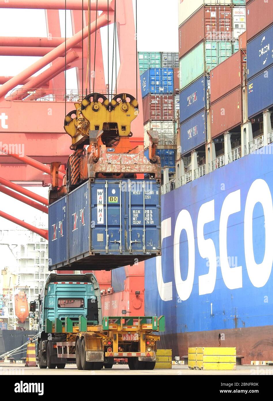 Trucks are busy at loading containers on vessels which export goods ...