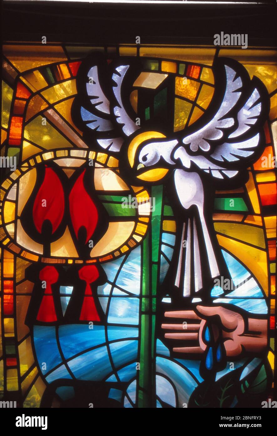 LOS ANGELES, UNITED STATES - May 07, 1985: Stained Glass window of Roman Catholic sacraments of Baptism and Confirmation with Holy Spirit as dove. Stock Photo