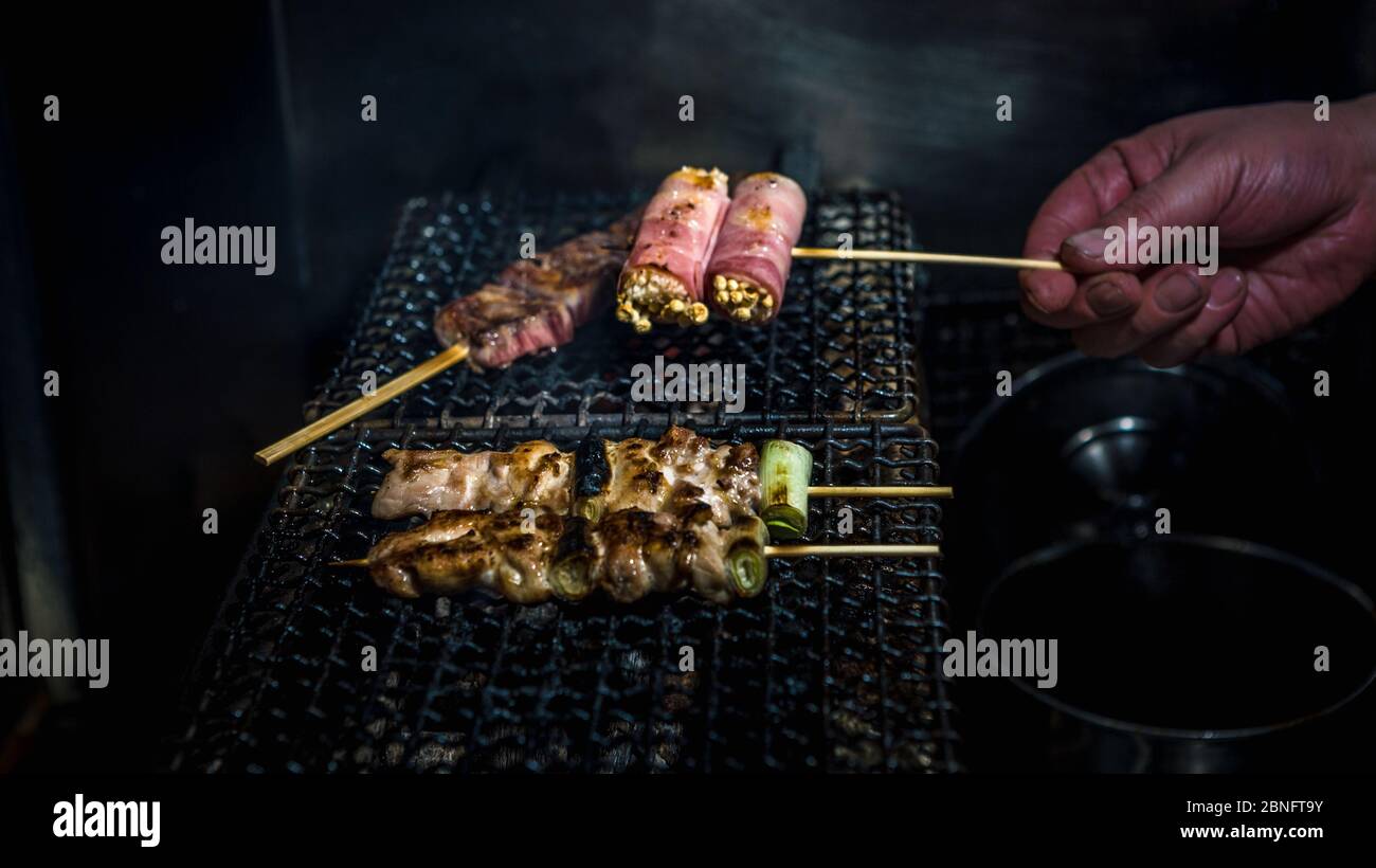Chef cooking inside izakaya Japanese bar in Tokyo. Traditional meat