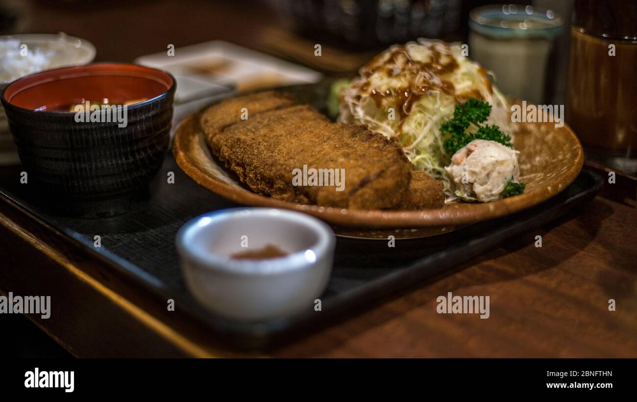 Plate of delicious fried crispy beef Gyukatsu on wood table. Featuring