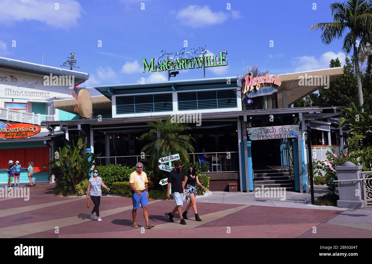 Orlando, United States. 14th May, 2020. Guests wearing face masks walk past Jimmy Buffett's Margaritaville restaurant at Universal Orlando's CityWalk as sections of the entertainment and retail district opened today for limited hours for the first time since Universal Orlando closed on March 15, 2020 due to the coronavirus pandemic. In addition to face coverings, temperature checks are also being required. Universal's theme parks will remain closed until at least May 31. Credit: SOPA Images Limited/Alamy Live News Stock Photo