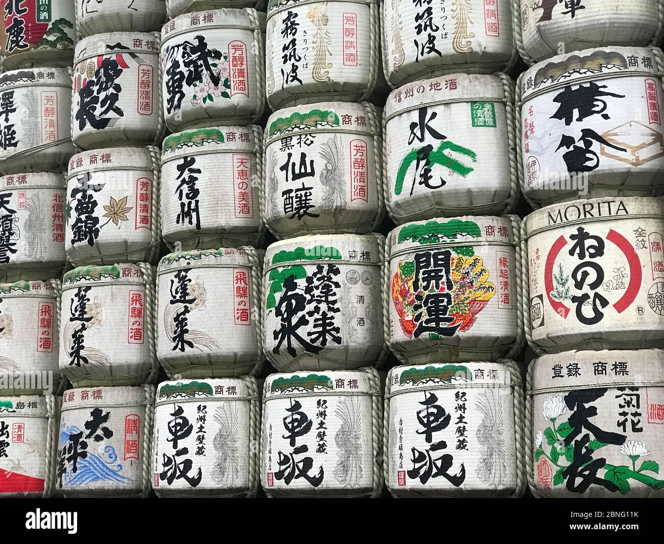 traditional Sake barrels at the entrance to Meiji  shrine in Tokyo.the writings in Japanese inform of the content of barrels and religious verses Stock Photo