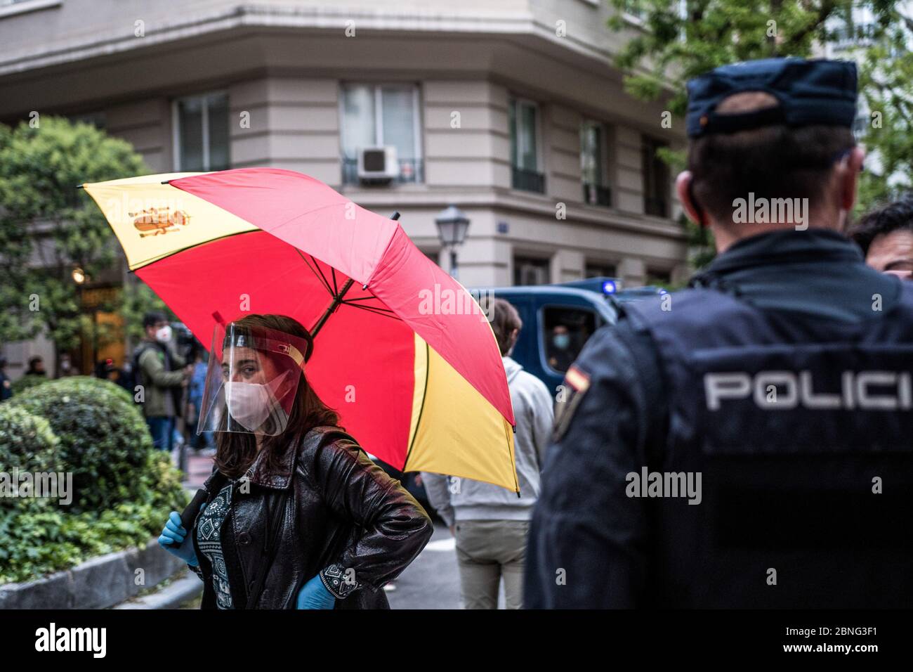 A woman wearing a face shield as a preventive measure holds an umbrella as she takes part during the demonstration The residents of the upscale Salamanca neighbourhood protest against the government's management of the coronavirus crisis. Some parts of Spain have entered "Phase One" transition since their coronavirus blockade, allowing many stores to reopen, as well as restaurants serving outdoor customers but the places most affected by the Covid-19, such as Madrid and Barcelona, remain in a stricter "Phase 0" quarantine. Stock Photo
