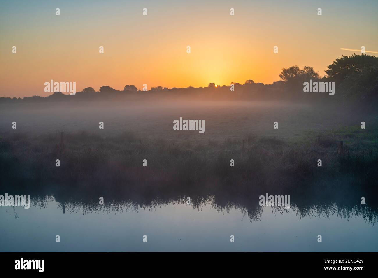 Misty sunrise on the Oxford canal in spring. Upper Heyford, Oxfordshire, England Stock Photo