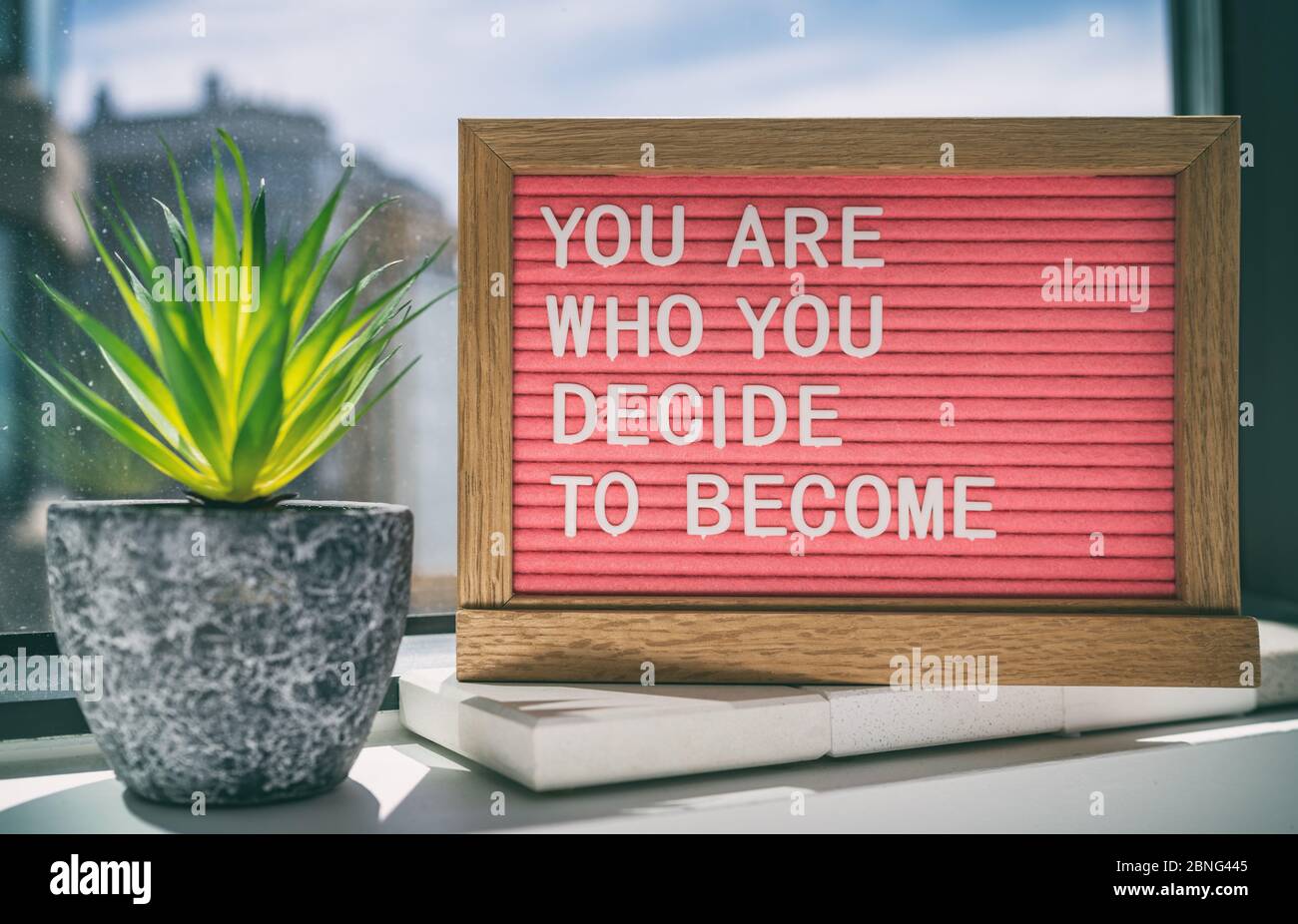 Inspiration quote message sign saying You are who you decide to become - life advice for self esteem, confidence. Home background. Stock Photo
