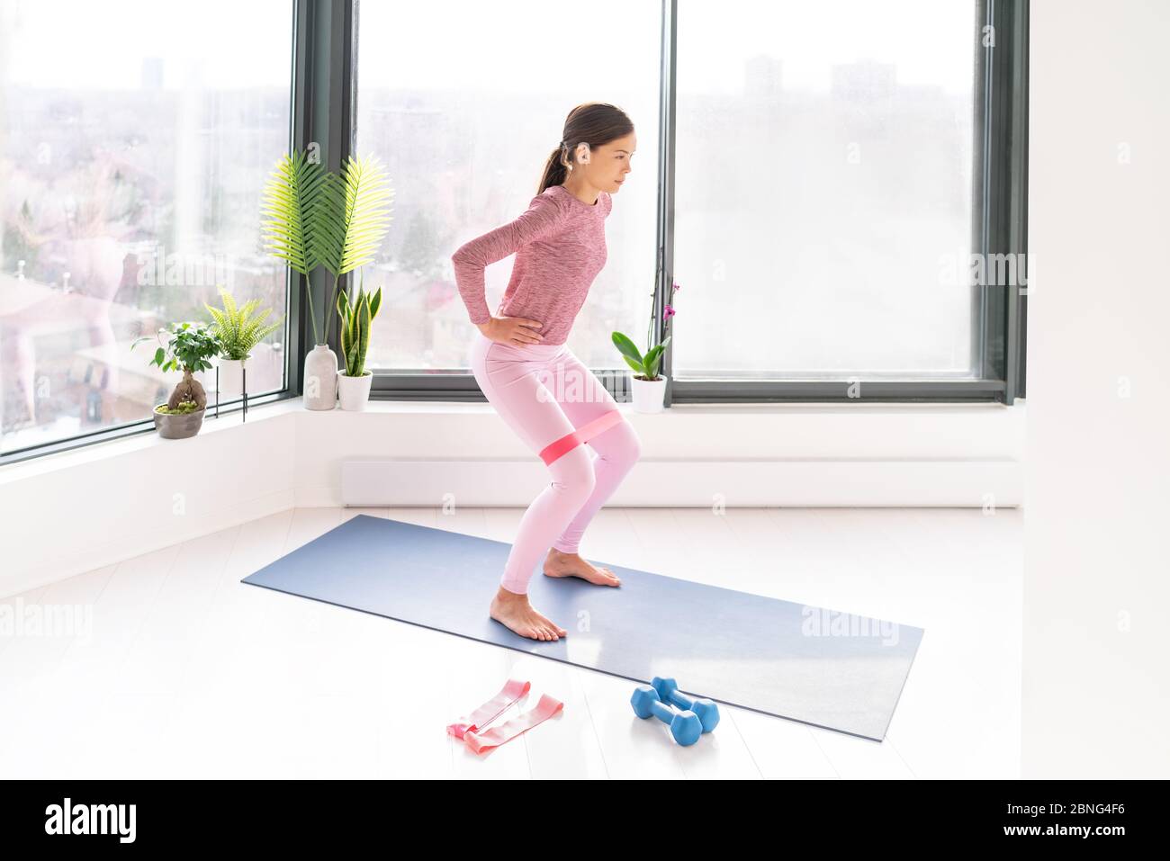 Resistance band fitness home workout woman doing squats exercises using