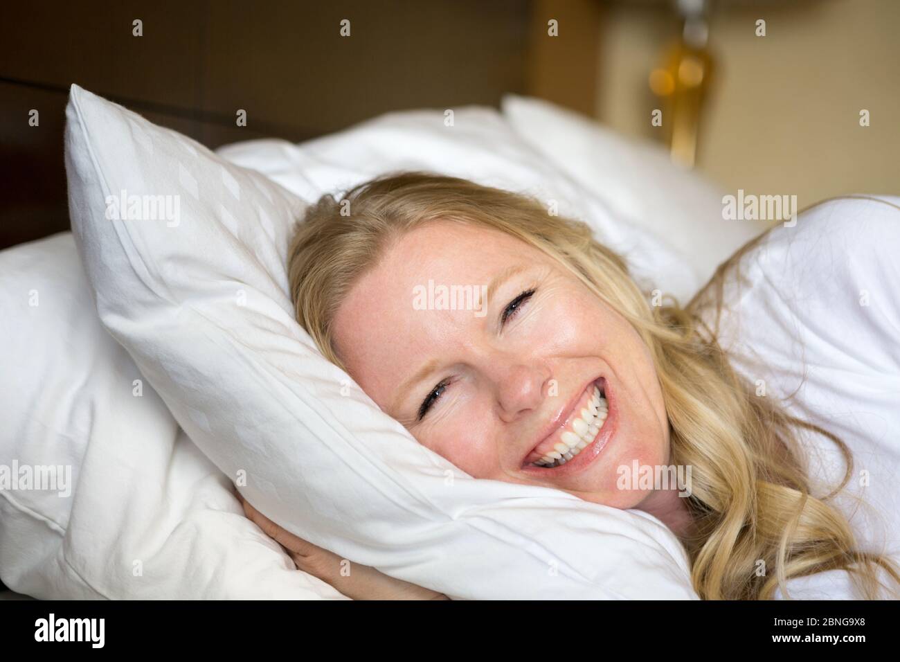 Beautiful woman smiling getting a good night sleep. Stock Photo