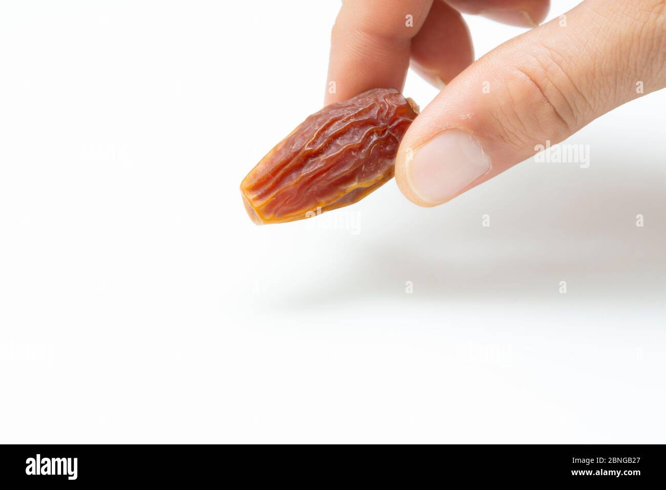 Hand holding  pitted dates isolated on white background Stock Photo