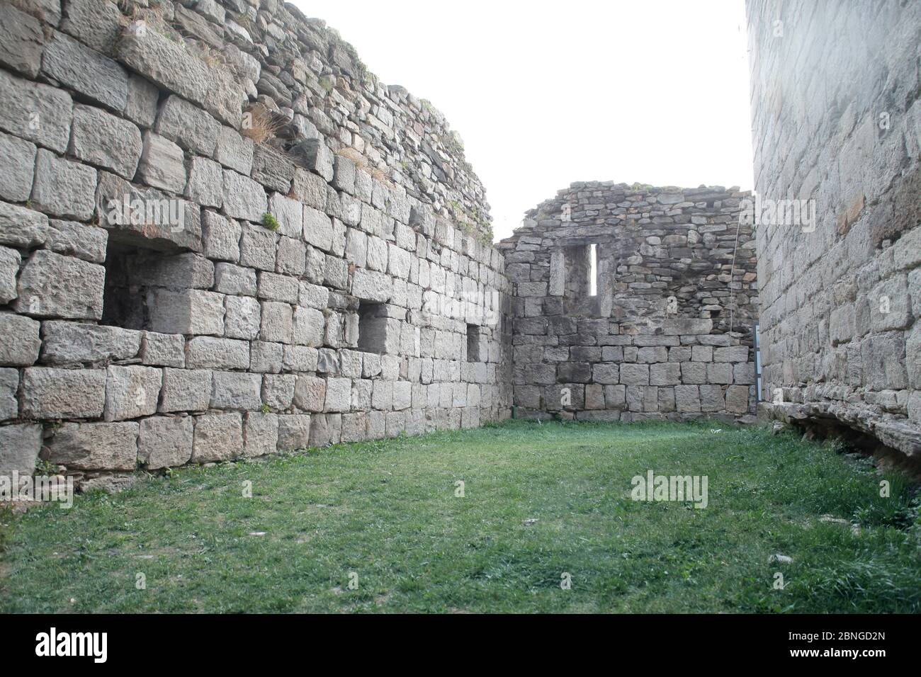 Old stone walls and a green grass in the middle Stock Photo - Alamy