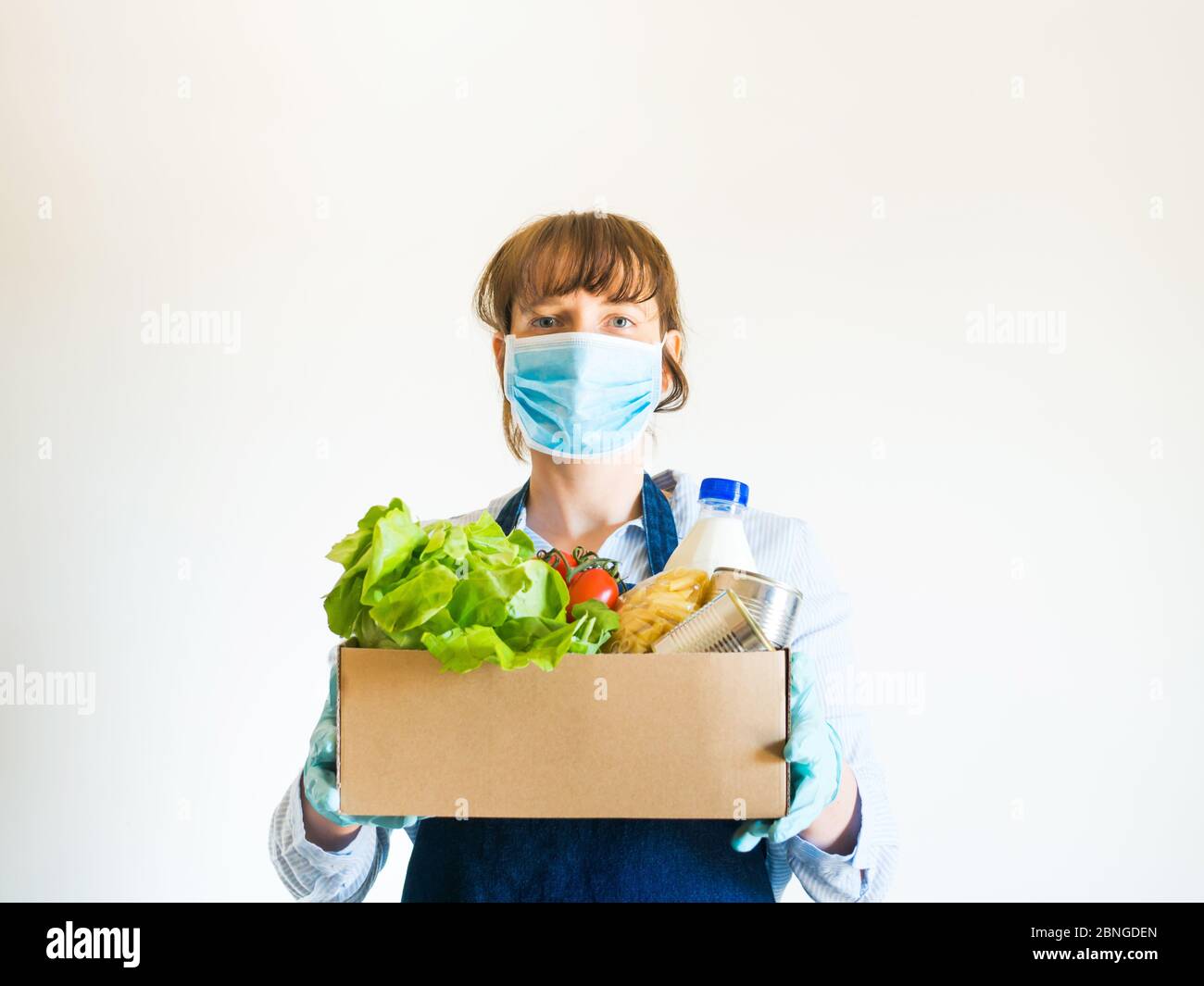 Woman in blue in face mask with food delivery box Stock Photo - Alamy