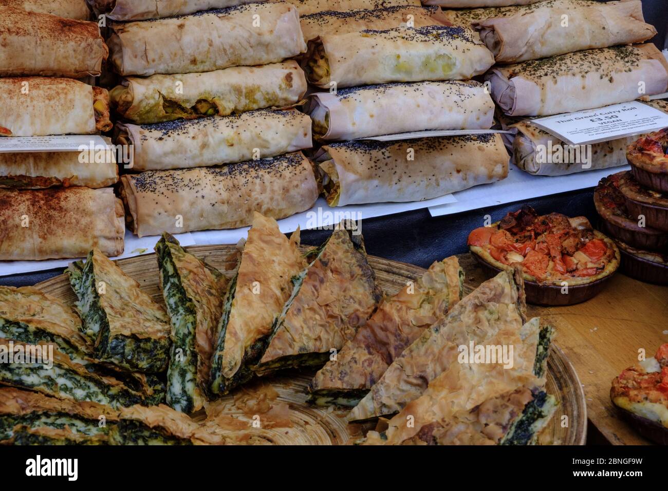 Display of spinach and cheese burek and Thai curry rolls for sale at