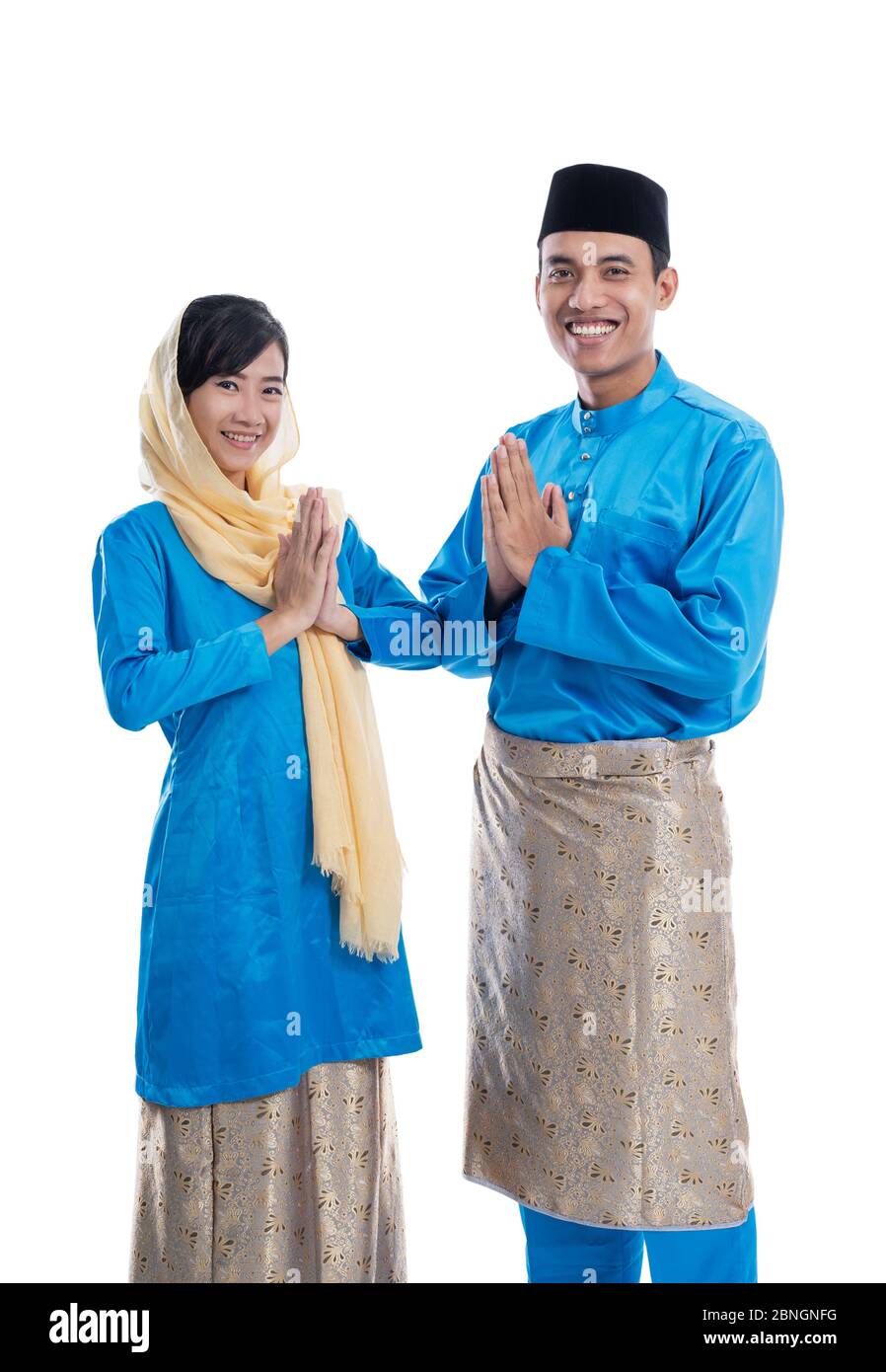 muslim malay couple with greeting gesture over white background. wishing you eid mubarak Stock Photo