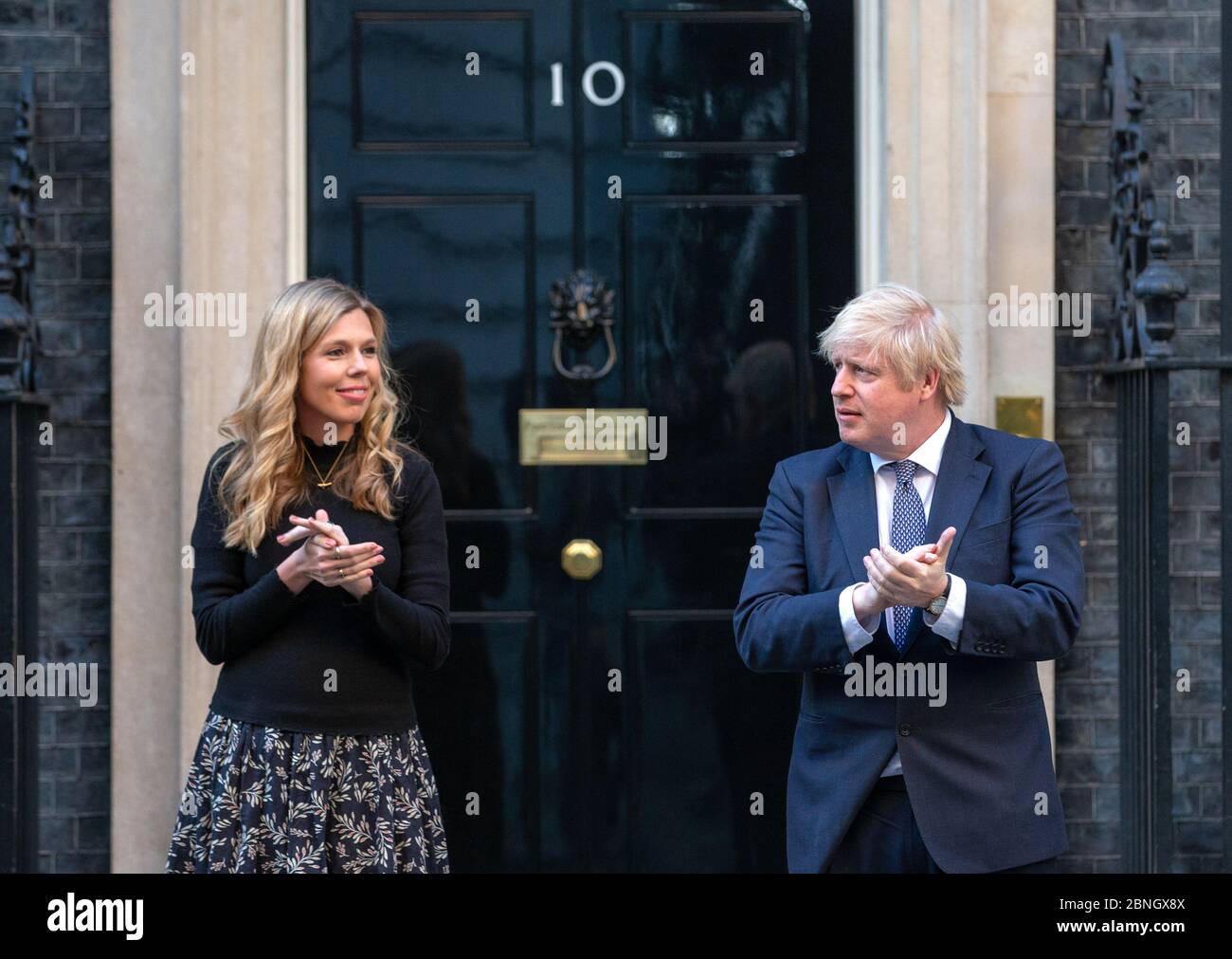 Prime Minister, Boris Johnson, is joined on the steps of 10 Downing Street by  fiancee Carrie Symonds to 'Clap for carers' supporting the NHS. Stock Photo