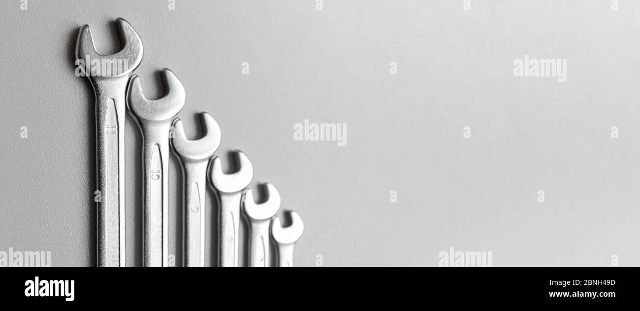 Spanners. Many wrenches. Grey background. Set of wrenches in different sizes on grey background.Banner. Stock Photo