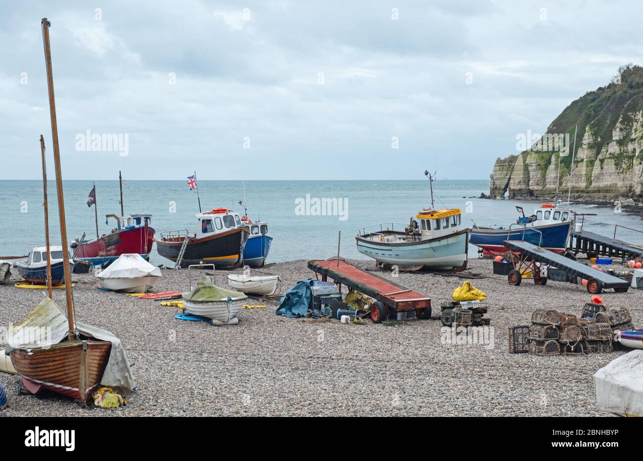 Some of the local fishing fleet stranded on the pebble beach at Beer in south east Devon, UK Stock Photo