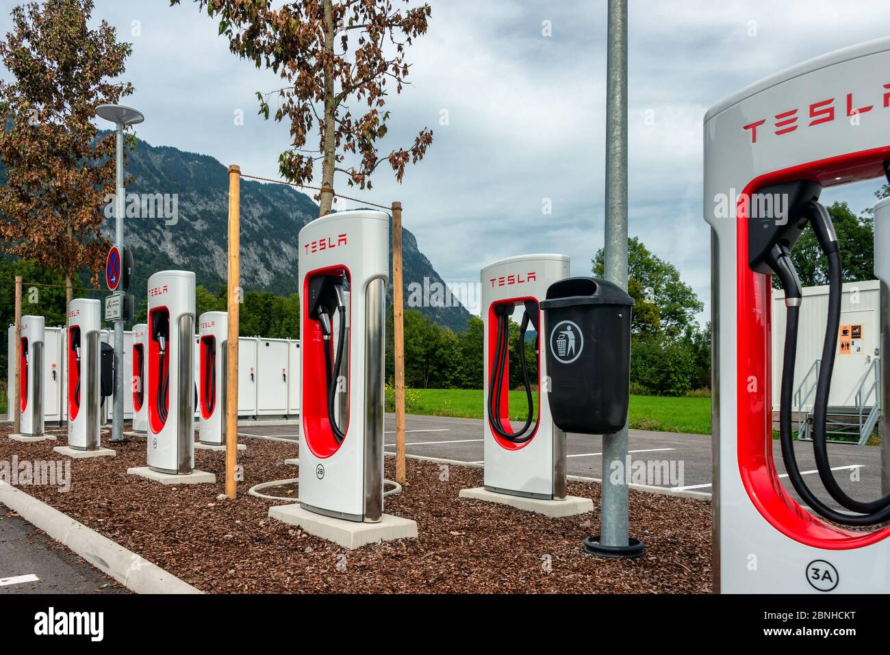 A Tesla electric car supercharger in a commercial parking lot Stock