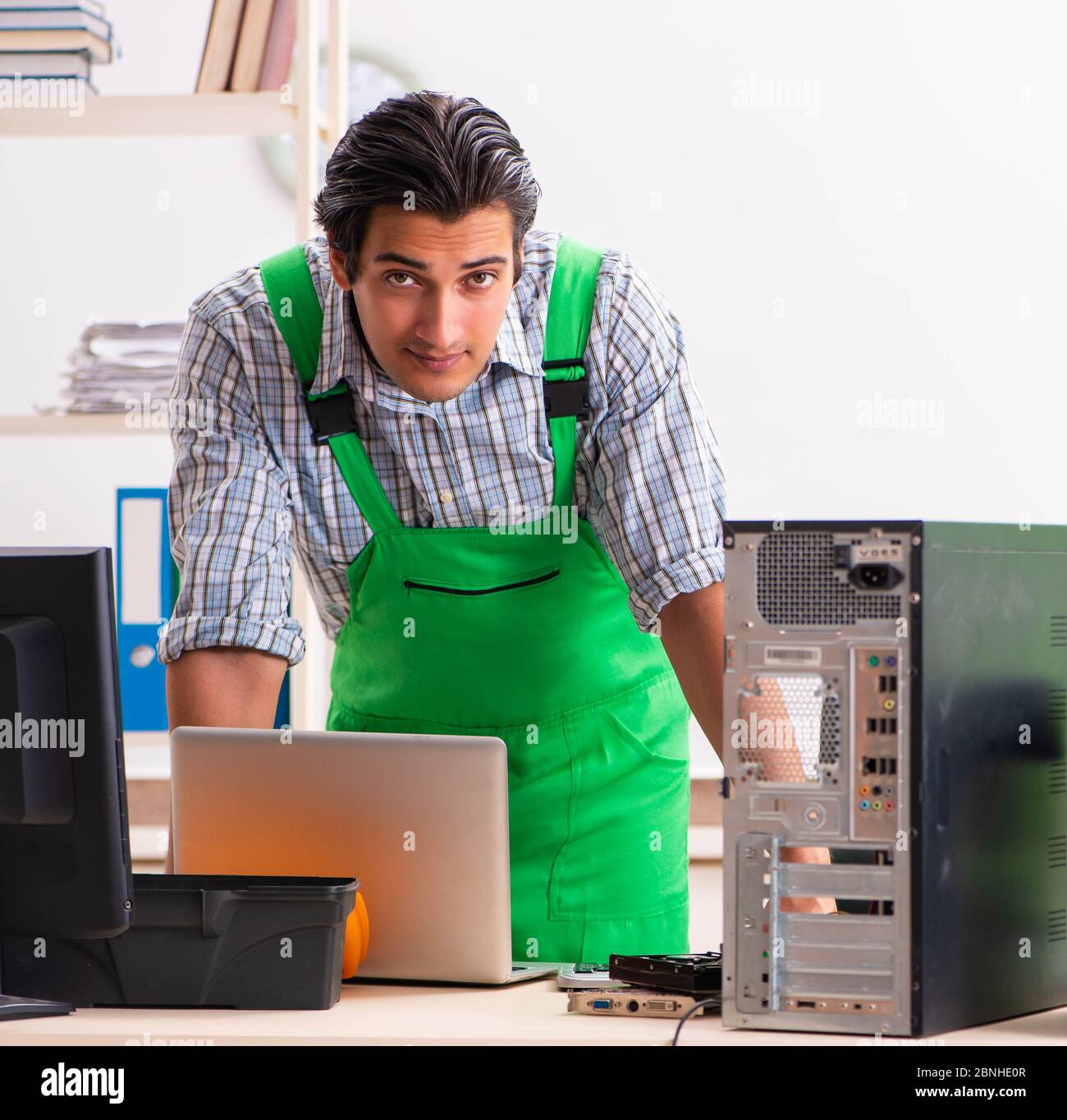 The young engineer repairing broken computer at the office Stock Photo ...