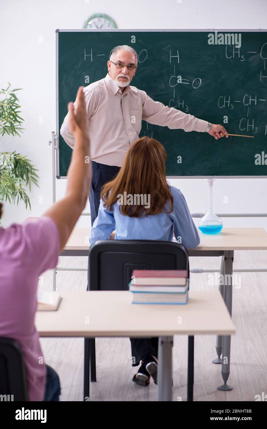 Old teacher and two students in the classroom Stock Photo - Alamy