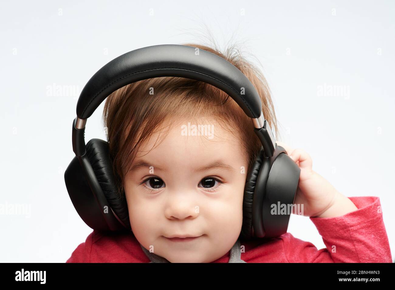 Funny portrait of baby with headphones isolated on white background Stock Photo