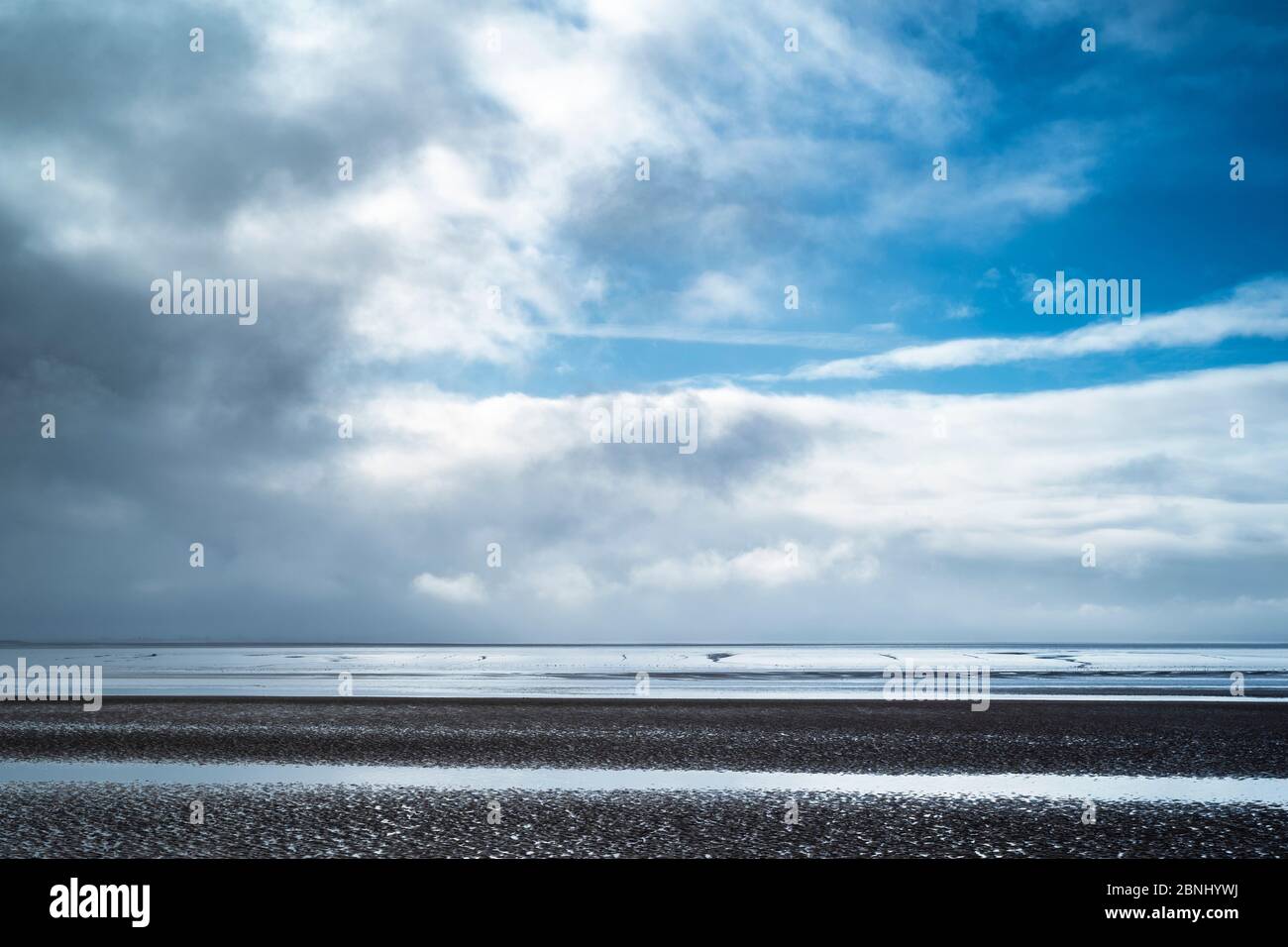 Pastel shades of sea and sandy beach under cerulean sky of the Bristol Channel at Burnham-on-Sea sea shore, Somerset, UK Stock Photo