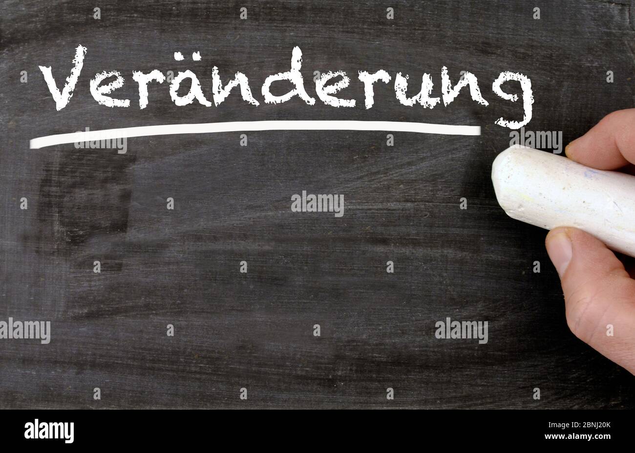 Hand writing the german word for changing on a blackboard Stock Photo