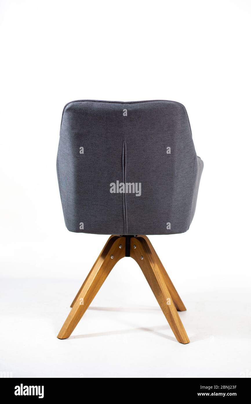 Vertical shot of the back of a gray chair behind a white background ...