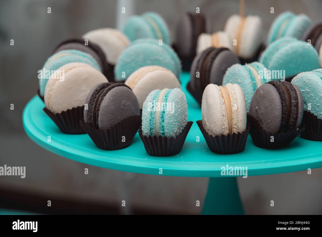 Light cream, tiffany blue and chocolate macaroons on tiffany blue stand. Food knolling concept Stock Photo