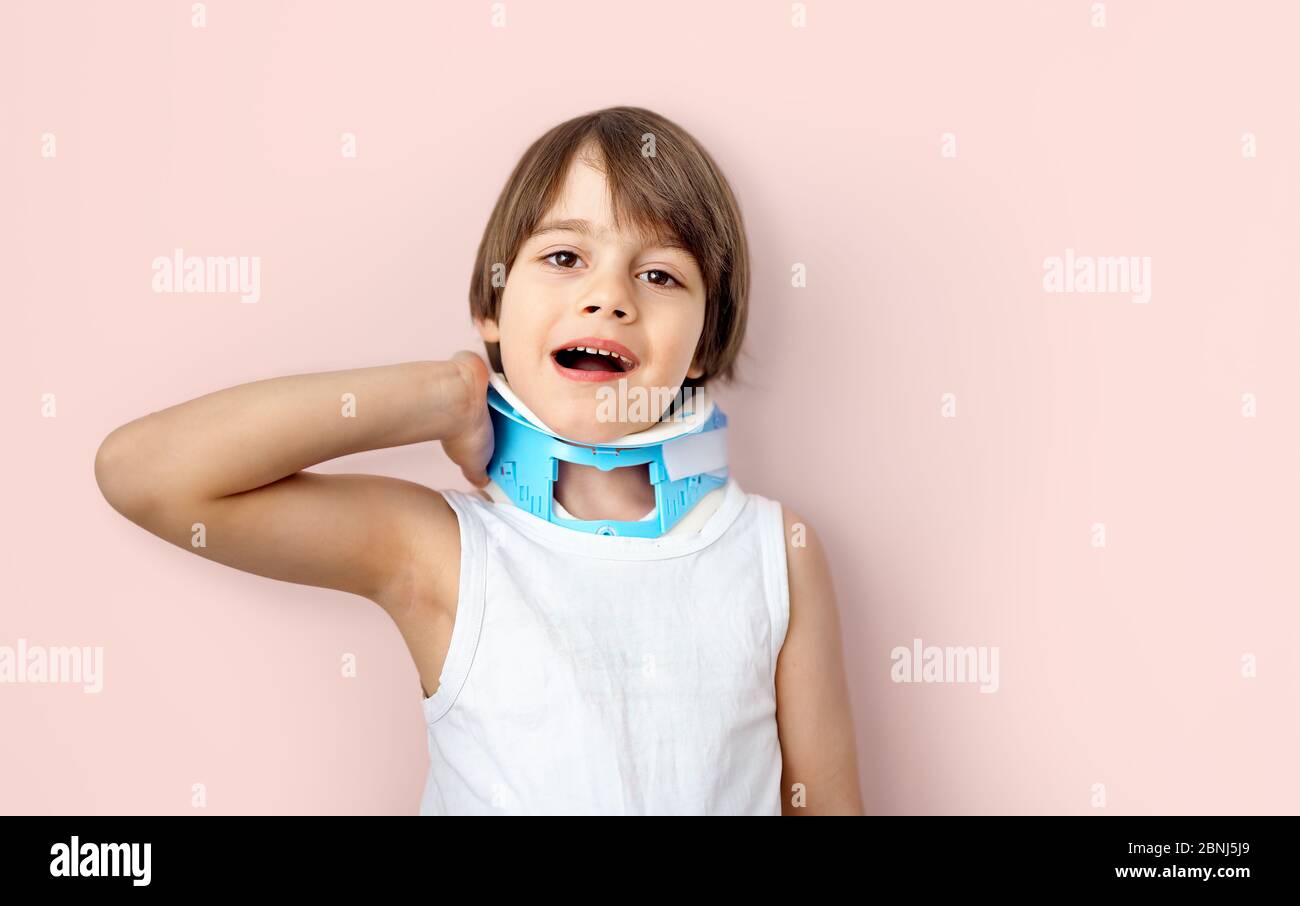 Little boy wearing Head Stabilizer or pediatric Cervical Collar accusing neck pain (Cervicalgia) and Torticollis. Common Childhood Injuries and Preven Stock Photo