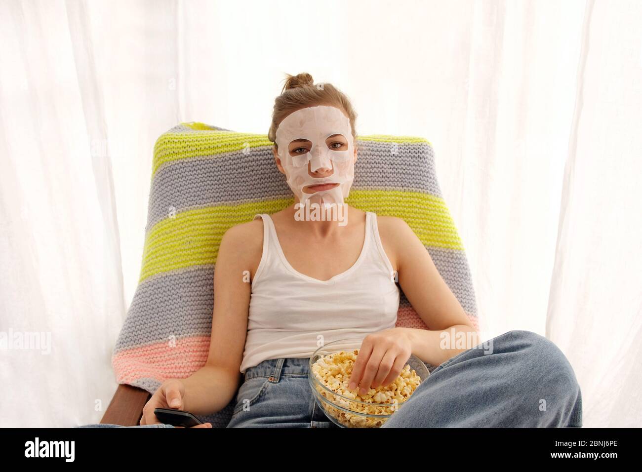Woman with a remote and popcorn Stock Photo