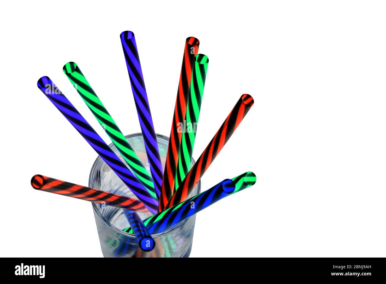 Neon colored plastic drinking straws placed in a glass.jpg Stock Photo