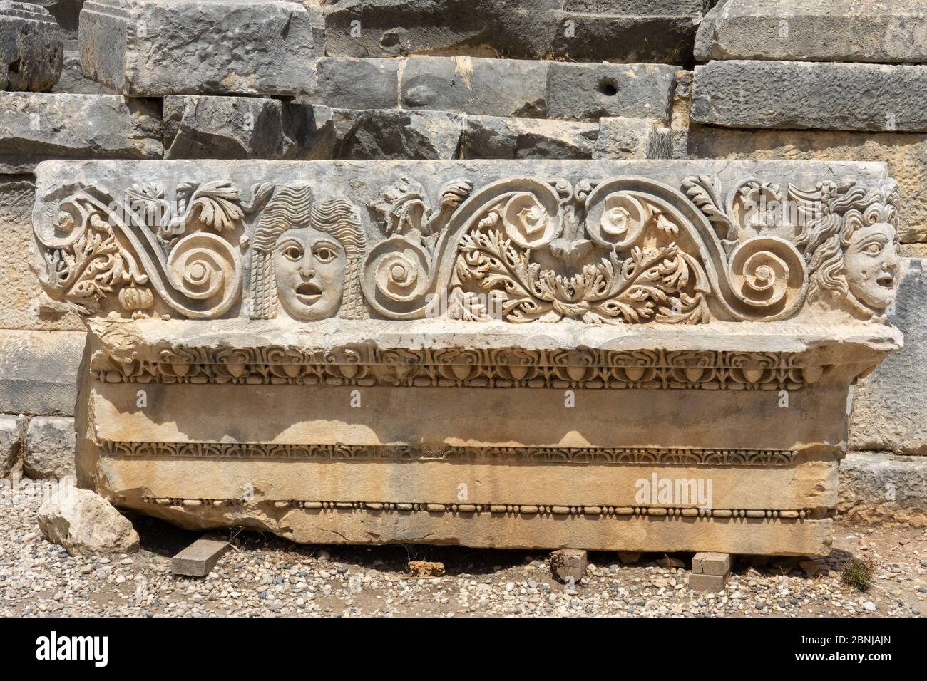 Fragment of the facade with the image of stone masks of the Greco-Roman amphitheater of the ancient city of Myra in Demre, Antalya Province, Turkey Stock Photo