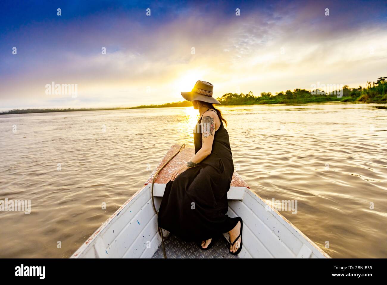 Woman enjoying sunset on the river, Amazon River, Peru, South America Stock Photo