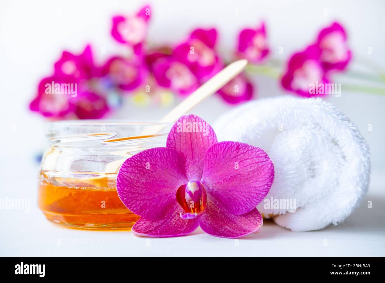 sugar paste or wax honey for hair removing with wooden waxing spatula sticks. flower background - depilation and beauty concept Stock Photo