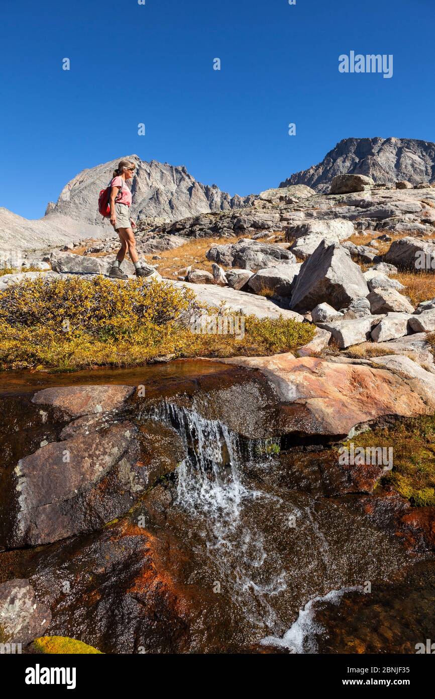 Hiker exploring Titcomb Basin, Wind River Range, Bridger Wilderness, Bridger National Forest, Wyoming, USA. September 2015. Model released. Stock Photo