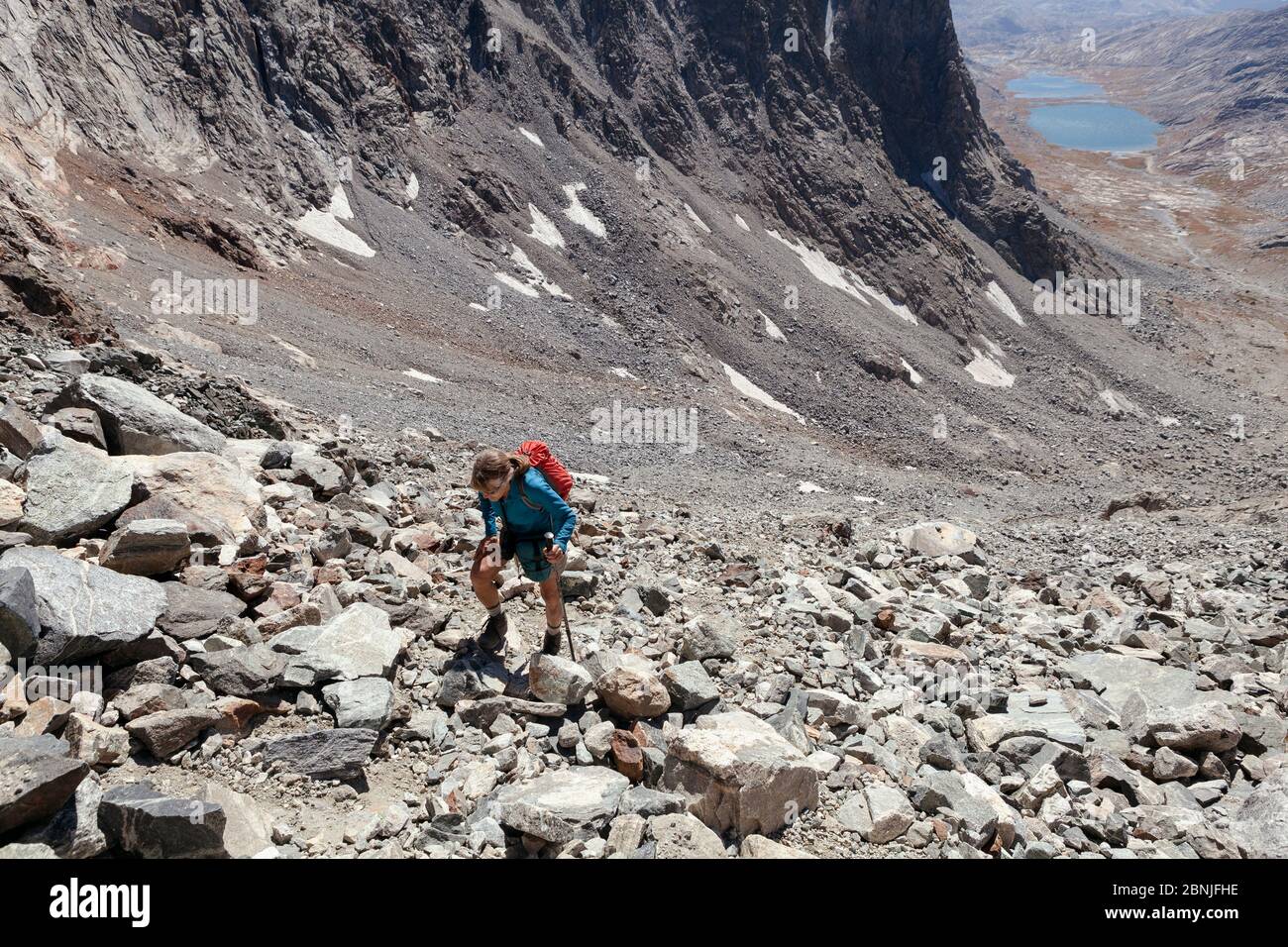 Hiker aproaching Dinwoody pass from Titcomb Basin, Wind River Range, Bridger Wilderness, Wyoming, USA. September 2015. Model released. Stock Photo