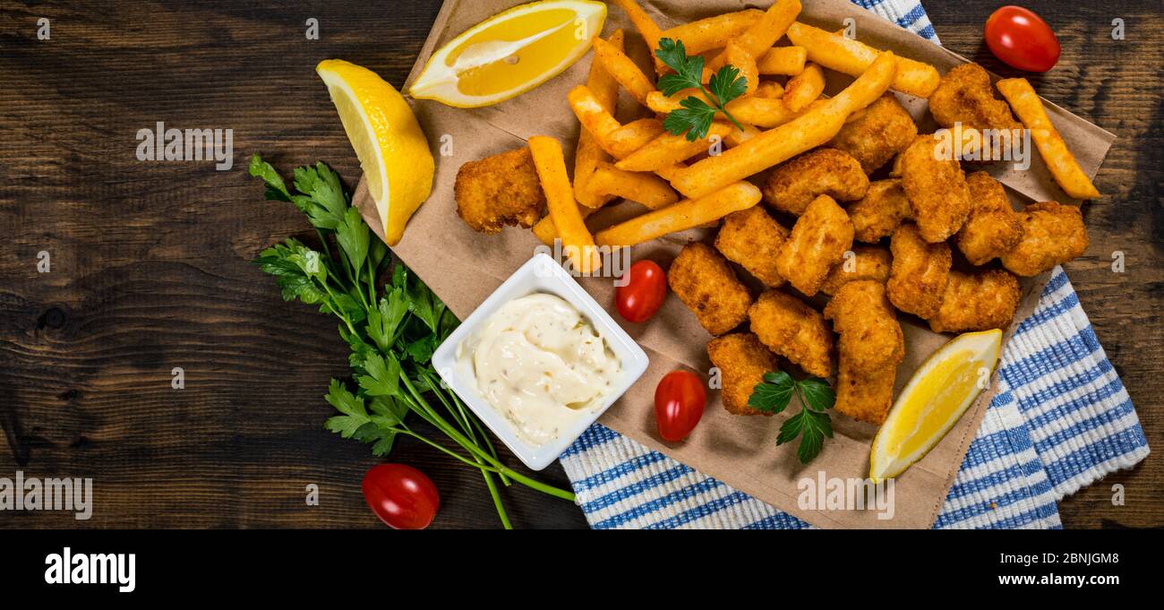 Crispy Fish Bites Snack Size. Deep Fried Pollock Fish Fingers with Tartar Dipping Sauce on a