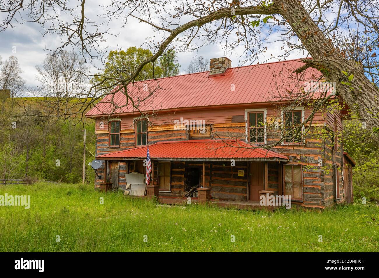 Tazewell, Tennessee, USA - April 28, 2020:  Seen from a country road, this old log home appears to be undergoing renovations. Stock Photo