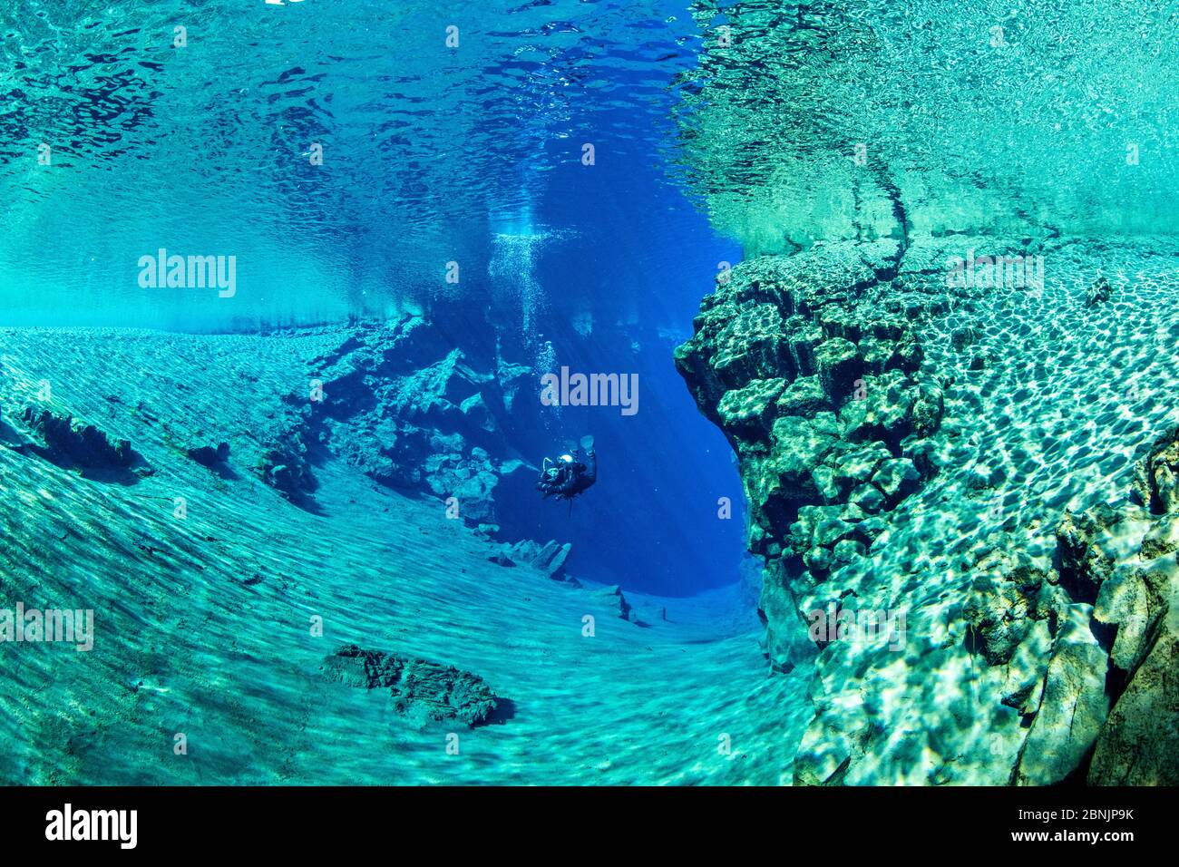 Diver exiting the cathedral at Silfra fissure, a deep fault filled with fresh water in the rift valley between the Eurasian and American tectonic plat Stock Photo