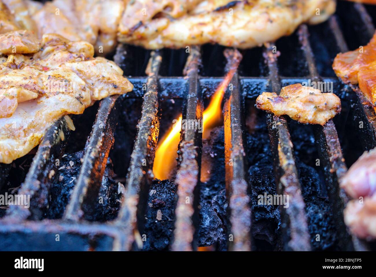 Meat being flame grilled on a barbecue, BBQ flame grill Stock Photo - Alamy